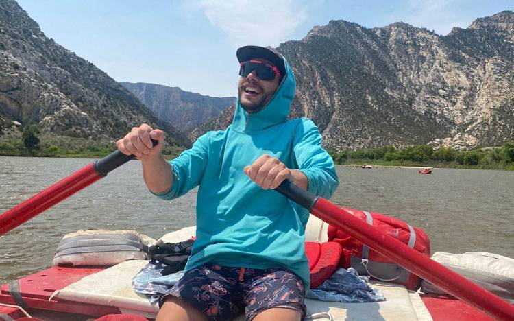 Jack Stauss rows a raft on the Green River with a big smile on his face.