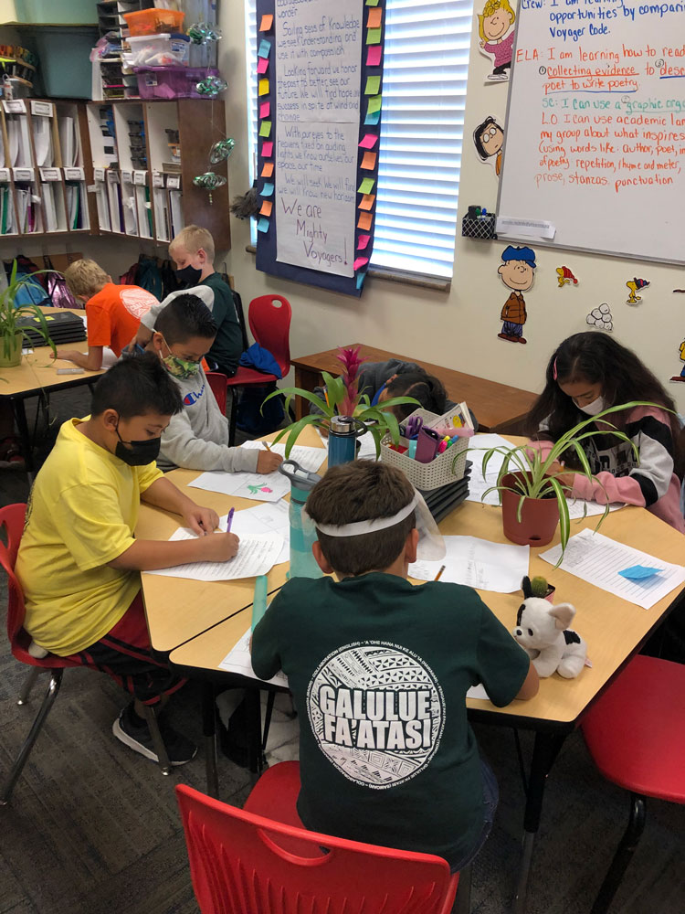 Fourth graders at Pacific Heritage Academy write about plants in a classroom.