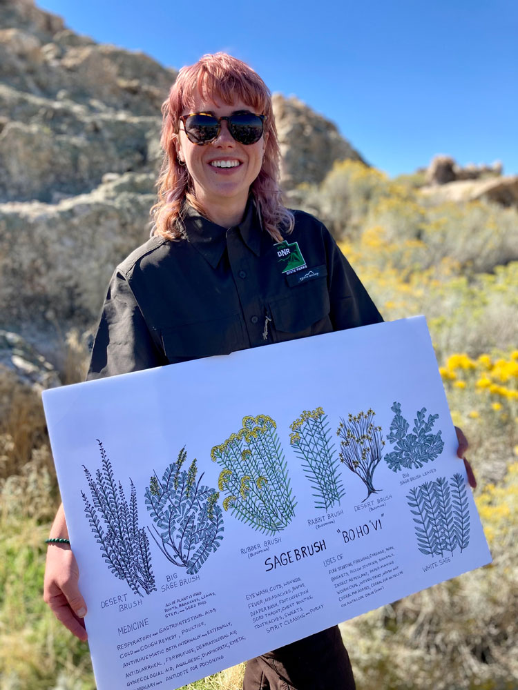 Fiona holding a sign created by Rios Pacheco educating about plants.