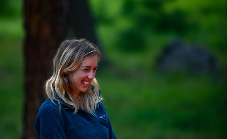 Morgan smiles in front of a green forest background.