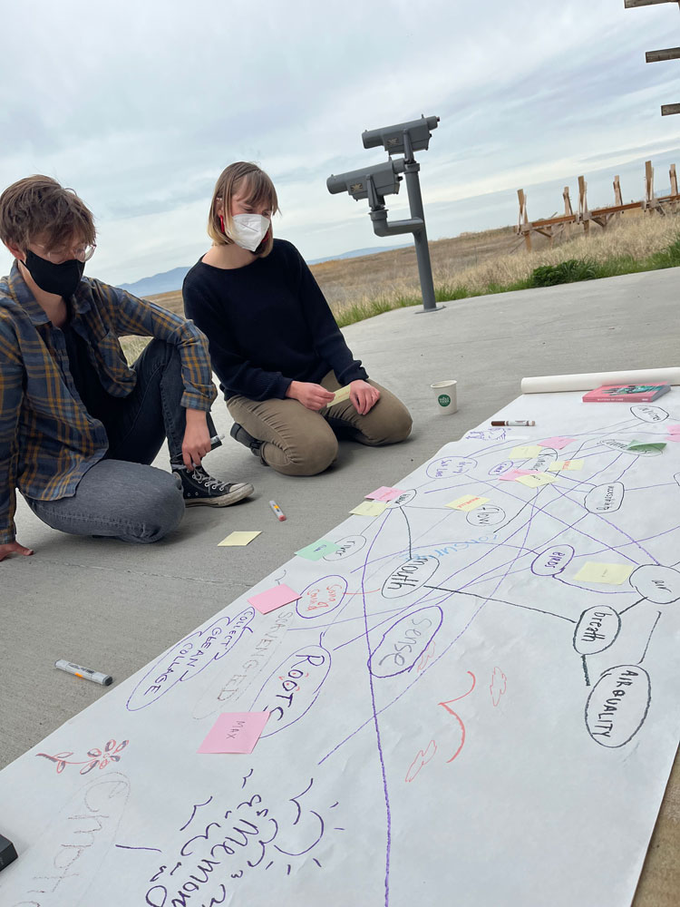 Natalie and Michelle Wentling, working group member, take notes on big sheet of paper outside at Farmington Bay.