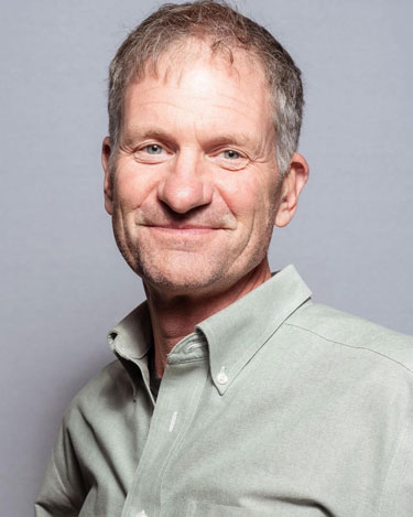 Headshot of Jeff McCarthy, a white man with short blonde and grey hair in a light green button up shirt in front a grey background.