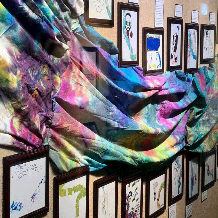 Close of up a tie-dyed banner and drawings by youth of their interpretation of water.