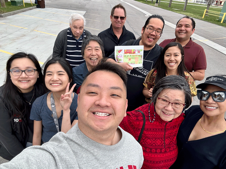 Pheej takes a selfie with a group of Asian American advocates on a walk outside.