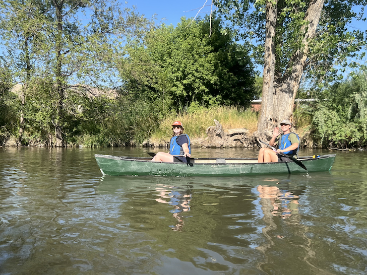 Olivia and another person on a canoe on the Jordan River. 