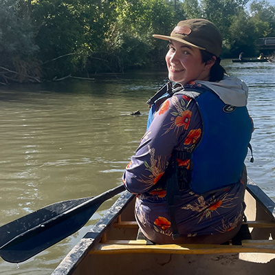 Erin O'Farrell turns back to the camera from a canoe